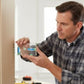 Homme installant niveau à bulle transparent magnétique sur mur blanc - outil précision bricolage professionnel