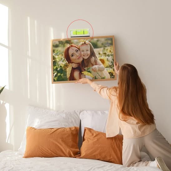 Utilisation du porte-clés niveau à bulle pour installer cadre photo au-dessus du lit