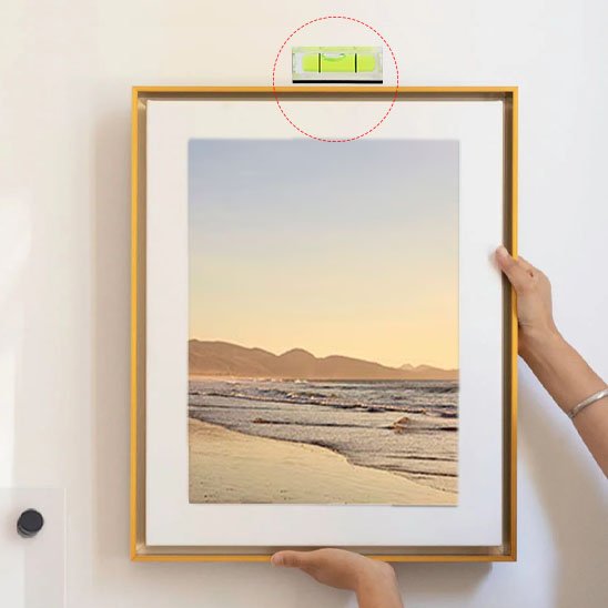 Porte-clés niveau à bulle utilisé pour aligner parfaitement un cadre photo au mur