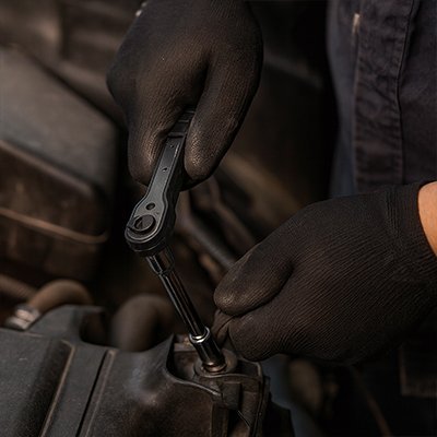 Mécanicien professionnel serrant un boulon avec clé à douille à tête articulée
