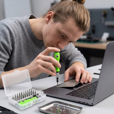 Homme vissant un MacBook avec un tournevis de précision 32 en 1