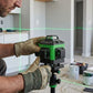 Mains avec gants tenant le niveau laser): "Ouvrier avec gants tenant niveau laser vert 360° professionnel sur trépied - outil mesure précision chantier