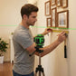 Homme mesurant avec niveau laser pour cadre): "Bricoleur utilisant niveau laser professionnel pour installer cadre mural - mesure alignement précis décoration