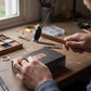 Mains artisan utilisant marteau à manche bois pour travaux délicats bijouterie création bagues
