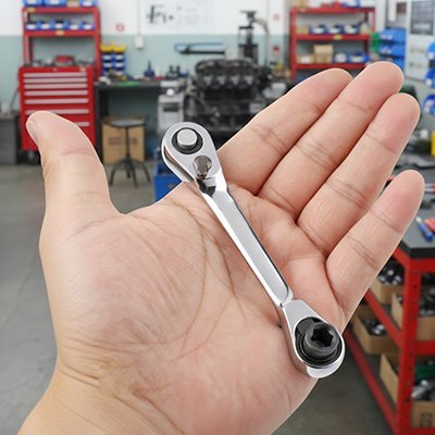 Mini clé à cliquet ergonomique utilisée dans un atelier professionnel
