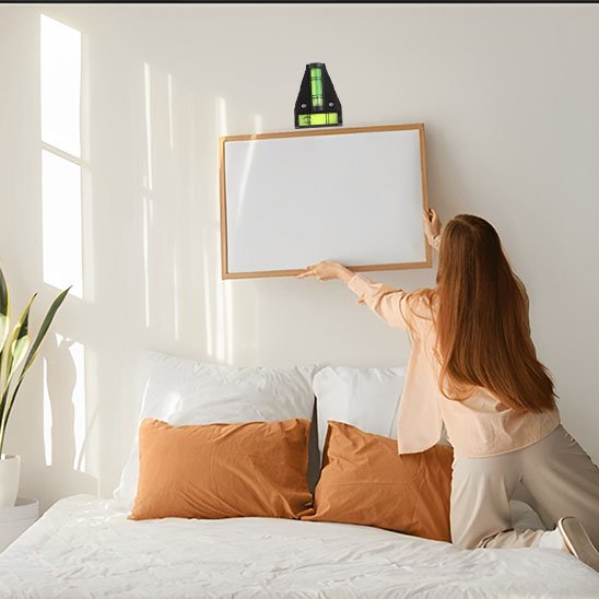 Femme utilisant niveau à bulle triangulaire pour accrocher cadre au mur - outil précision bricolage