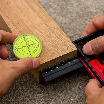 Bulle à niveau circulaire verte sur planche bois avec équerre - outil de mesure menuiserie