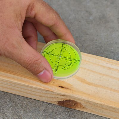 Bulle à niveau ronde fluorescente posée sur bois - vérification horizontalité précise