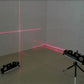 Niveau laser avec trépied projetant lignes horizontales et verticales rouges sur mur - démonstration en intérieur"
