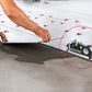 Artisan utilisant niveau laser pour pose précise de carrelage 