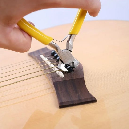 Main tenant pince coupante professionnelle jaune pour couper cordes de guitare acoustique - outil bricolage précision