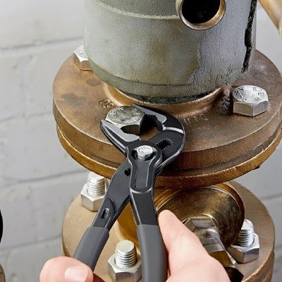 Pince multiprise acier forgé serrant écrou laiton sur tuyauterie - outil professionnel robuste
