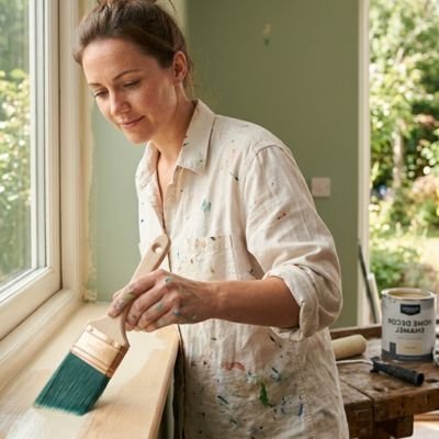 Pinceau professionnel utilisé par une femme pour peindre une boiserie intérieure