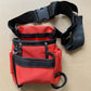 Sac à outils pour taille rouge avec bandes noires, ceinture ajustable et boucle de fixation