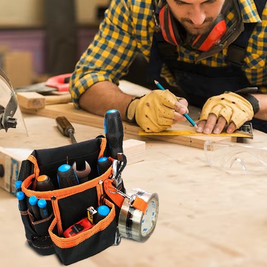 Artisan portant un sac à outils pour taille rempli d'outils dans un atelier de menuiserie