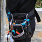 Sac à outils pour taille noir avec bandes grises posé à plat montrant les multiples poches et compartiments
