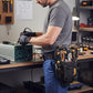 Technicien en atelier utilisant une porte-outils ceinture pleine d'outils
