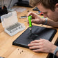 Technicien réparant un ordinateur portable avec un tournevis de précision 32 en 1