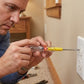 Utilisation d'un tournevis testeur sur une prise murale pour détecter la tension
