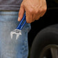 Clé à molette bleue tenue près d'une voiture