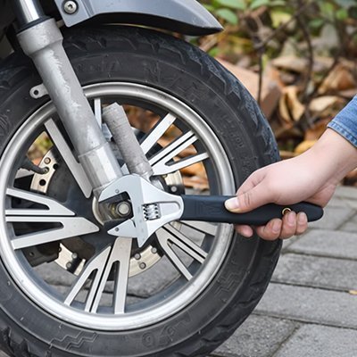Clé à molette professionnelle réglable utilisée sur roue de moto – manche ergonomique noir