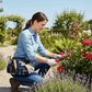 Femme travaillant au jardin avec sac banane et outils de jardinage