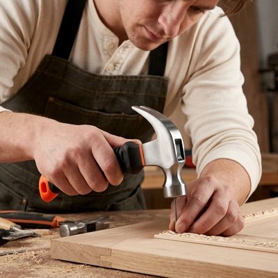 Homme enfonçant clou avec marteau griffe sur bois