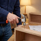 Homme assemblant meuble avec marteau griffe compact
