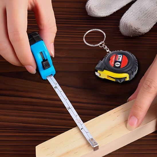 Mètre-ruban miniature porte-clés 1m déroulé sur planche de bois – coloris jaune, avec médaillon taille réelle