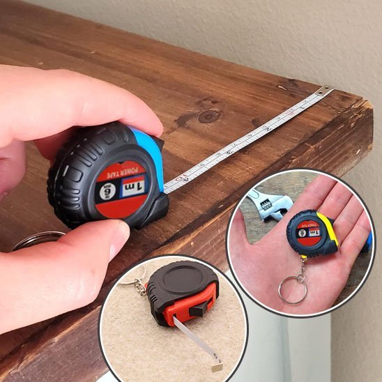 Mètre-ruban miniature porte-clés 1m Power Tape bleu déroulé sur planche de bois – médaillons coloris rouge et jaune