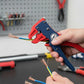 Pince à dénuder rouge et bleue dénudant un câble tricolore sur un établi d'atelier