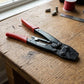 Pince à sertir professionnelle rouge noire établi bois