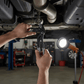 Mécanicien utilisant pince multiprise ajustable noire sous voiture dans garage automobile - outil polyvalent professionnel