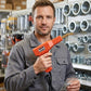 Technicien tenant pistolet à souder plastique orange en magasin