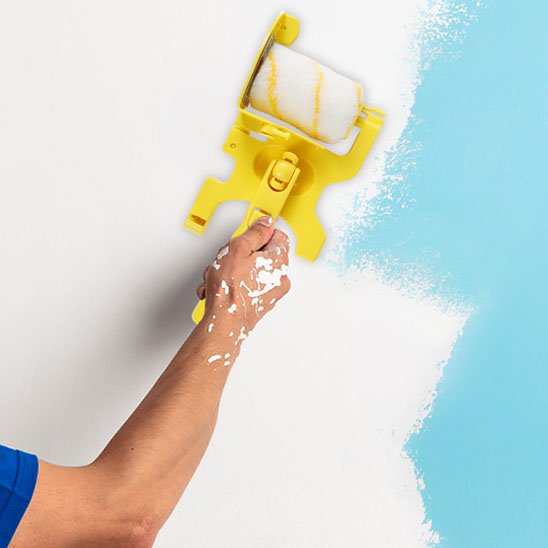 Rouleau peinture traçant une ligne bleue sur mur blanc