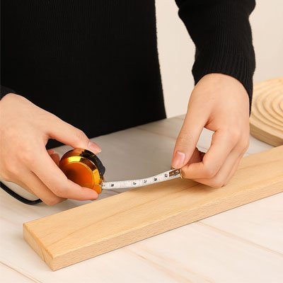 Ruban mètre porte-clés 2m utilisé pour tracer une mesure sur planche de bois – coloris or