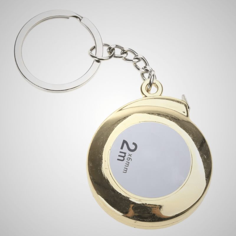 Ruban mètre porte-clés 2m x 6mm – boîtier rond coloris or, chaîne argentée, fond gris