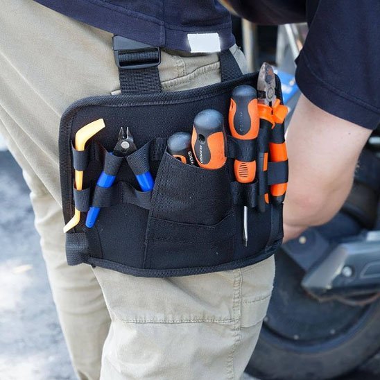 Vue rapprochée du sac à outils pour taille noir montrant les poches organisées avec pinces et tournevis
