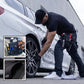 Mécanicien automobile portant un sac à outils pour taille noir avec outils rouges, travaillant sur une jante de voiture