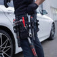 Mécanicien portant un sac à outils pour taille noir avec outils rouges et noirs, travaillant sur une voiture