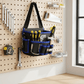 Sac banane noir et bleu sur mur d'établi avec outils